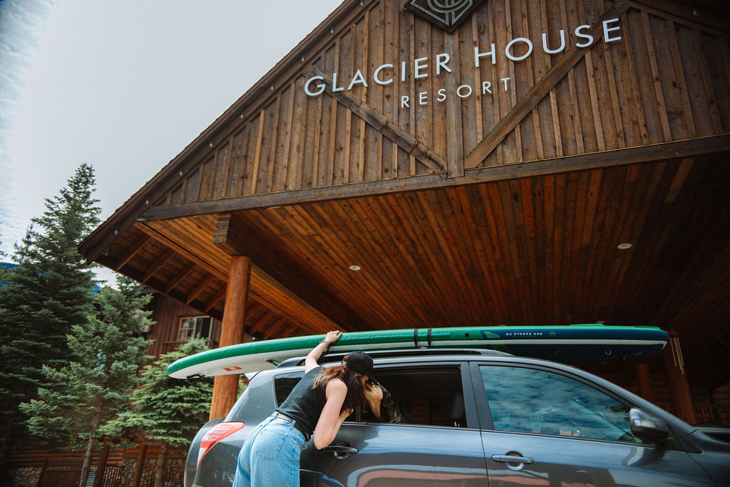 A paddle boarder get ready to depart in front of the lodge