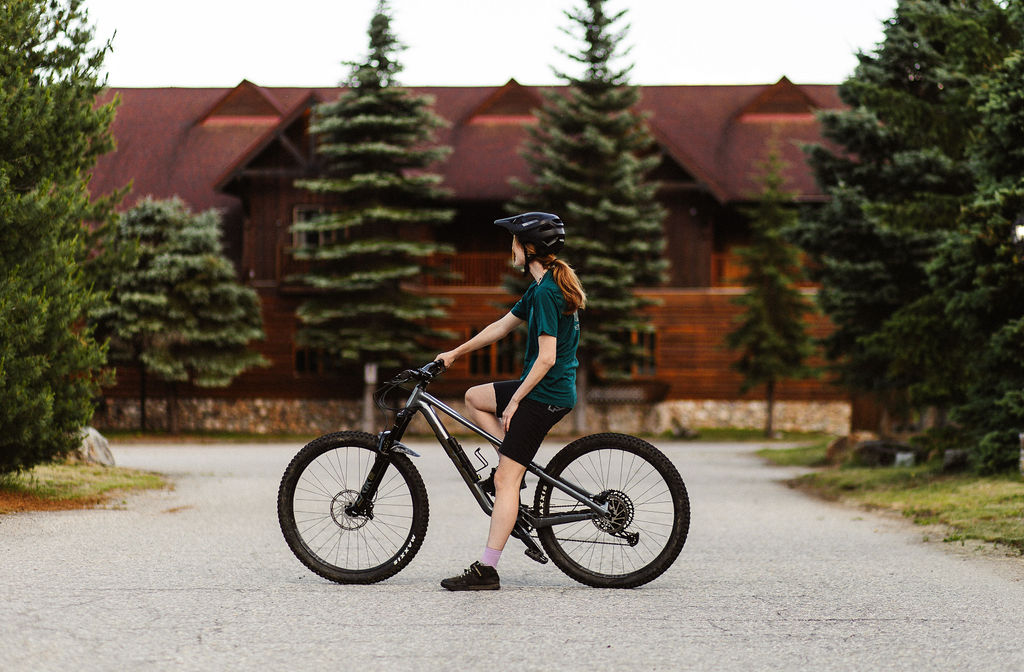 A cyclist stops in front of the Glacier House Resort lodge