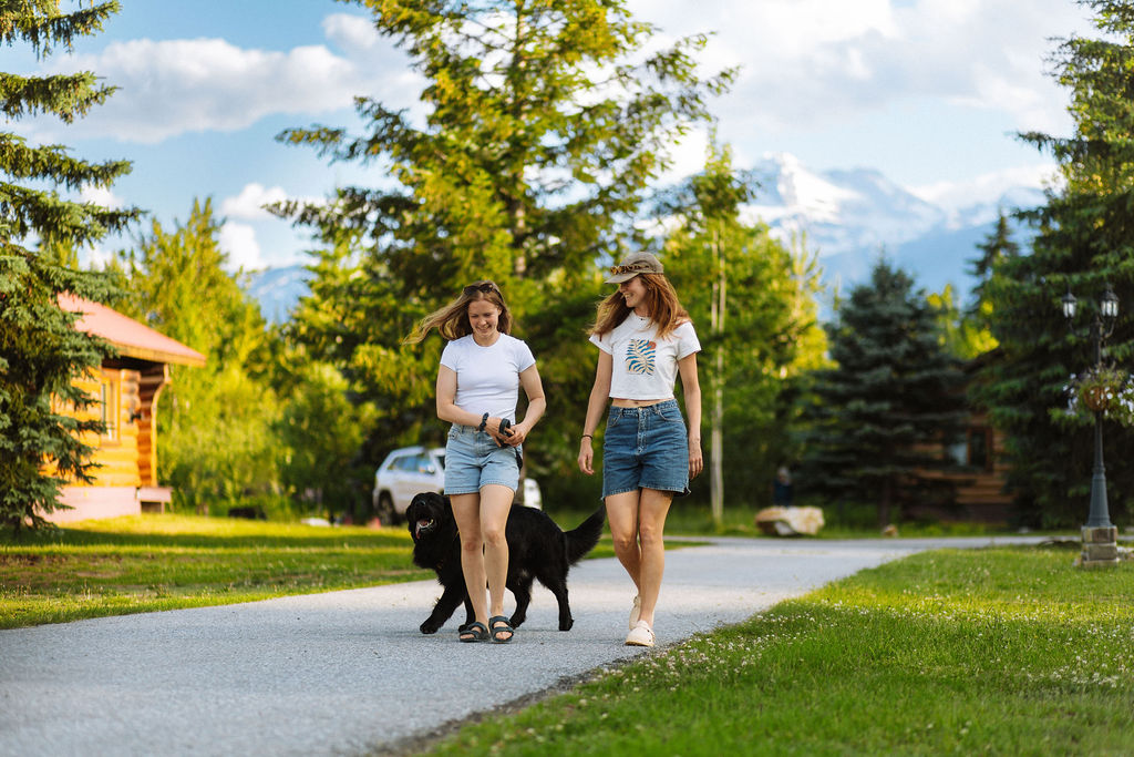 2 women walk a dog around the resort property